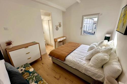 une petite chambre avec un lit et une fenêtre dans l'établissement The Lighthouse Quiet terrace apartment on the port, à Saint-Martin-de-Ré