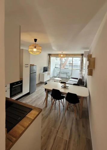 une cuisine et une salle à manger avec une table et des chaises dans l'établissement Appartement 37m2, parking, wifi, clim, centre-ville port, à La Grande Motte