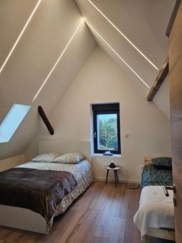 - une chambre mansardée avec 2 lits et une fenêtre dans l'établissement House La Belle Escapade, à Sainte-Croix-en-Plaine