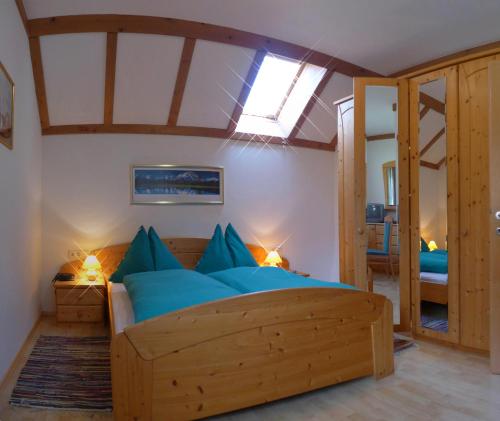 a bedroom with a large wooden bed with blue pillows at Ferienhaus-Birgit-Gerald-Reinbacher in Gröbming