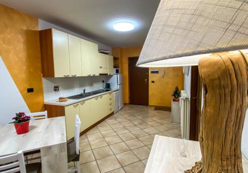 a kitchen with white cabinets and a table and a counter top at Pa e Ma alloggio Chatillon con parcheggio gratis in Châtillon