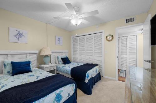 una camera da letto con due letti e un ventilatore a soffitto di Beachfront Aldea 6 a Clearwater Beach