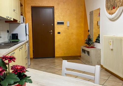 a kitchen with a brown door and a white chair at Pa e Ma alloggio Chatillon con parcheggio gratis in Châtillon