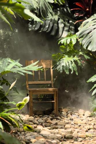 a wooden chair sitting on top of a pebbleysical at Thỏ Non Garden - Bảo Lộc Center 02 in Bao Loc