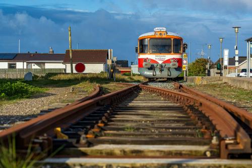 a train is coming down the tracks at Dejlig gårdhave 5 soveværelser in Harboør