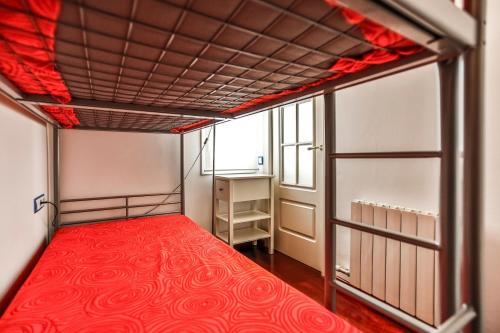 a bed in a room with a red mattress at Montroig Mar in Sitges