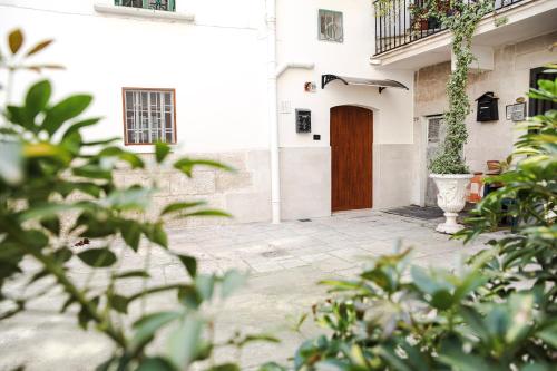 a white building with a brown door and plants at Dante 25 in Triggiano