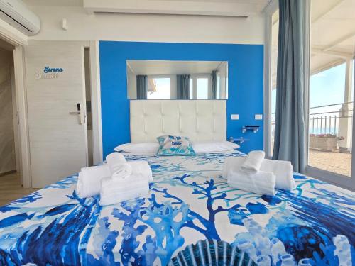 a bedroom with a blue and white bed with two chairs at Suite Torre Azzurra B&B - Rooftop Sea View in Follonica