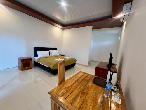 a bedroom with a bed and a table in it at Pohon Purba Resort & Restaurant in Labuan Lombok