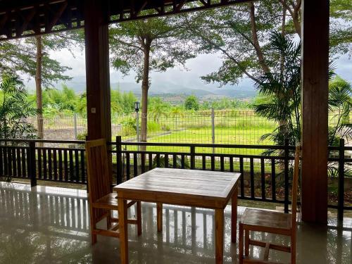 a table and two chairs on a porch with a view at Pohon Purba Resort & Restaurant in Labuan Lombok