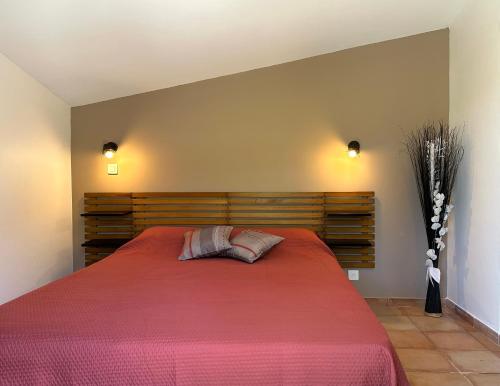 a bedroom with a large bed with a red blanket at village vacances du camboussel in Brassac