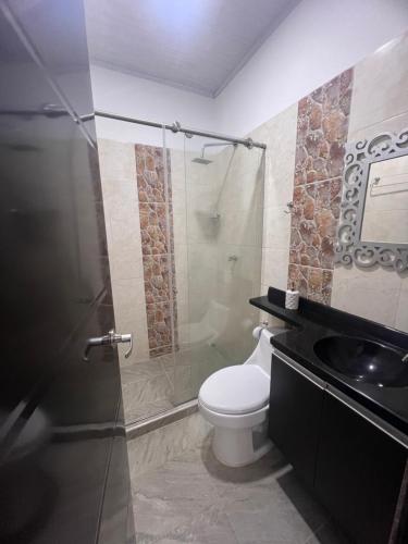 a bathroom with a toilet and a glass shower at Finca Hotel Villa el Ocaso Huila in Rivera