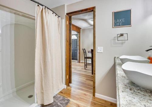 a bathroom with a tub and a sink and a mirror at Lake Milton 1 Block From Beach With A Hot Tub in Lake Milton