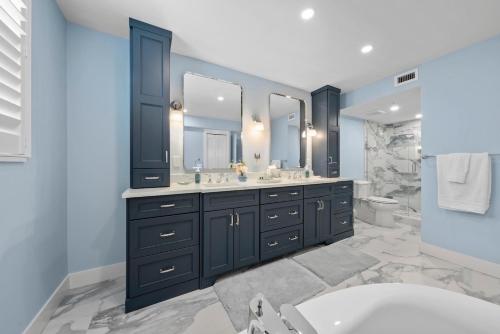 a bathroom with two sinks and a toilet and a tub at Pine Cove 104 in Sanibel