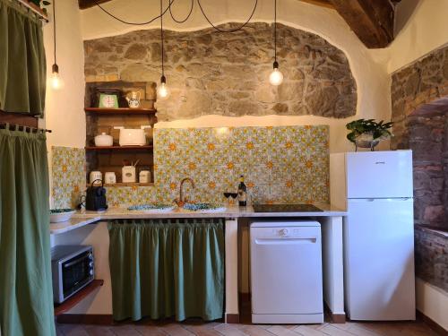 a kitchen with a sink and a refrigerator at Casa Vacanze Uno Sguardo Sul Borgo in Montecatini Val di Cecina