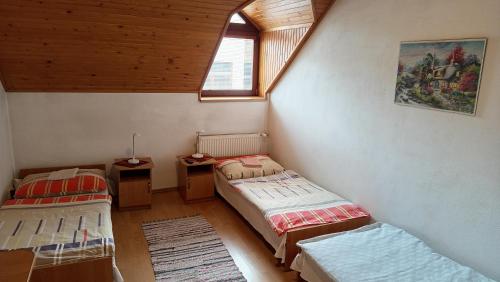 a room with two twin beds and a window at Penzion Kokava in Kokava na Rimavica