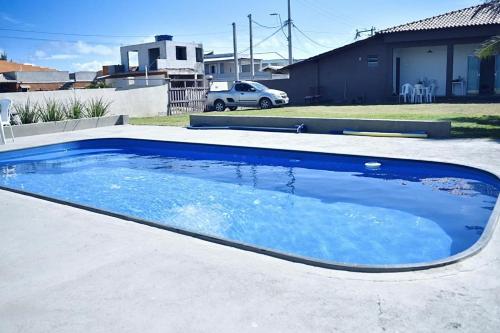 a large blue swimming pool in a driveway at Iris Pousada Hostel Arraial do Cabo in Arraial do Cabo