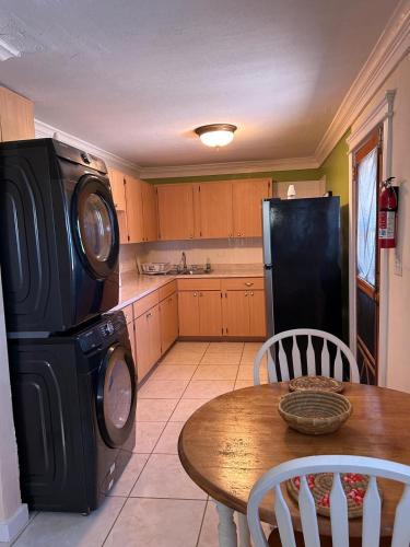 a kitchen with a table and a black refrigerator at Treasures of Andros in Love Hill