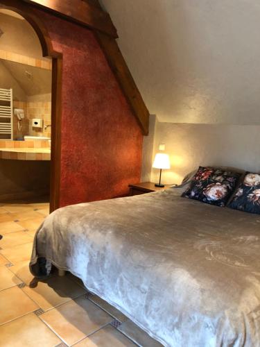 a bedroom with a large bed and a bathroom at Chez MASK Brocante in Yvetot Bocage