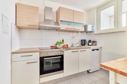 a kitchen with white cabinets and a stove top oven at Olivia -Einzigartiges Wohnerlebnis in Kaiserslauterns Herz in Kaiserslautern