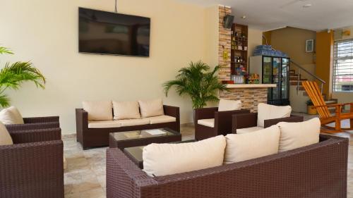 a living room with couches and a tv at Hotel y Cabañas Covemar in Coveñas