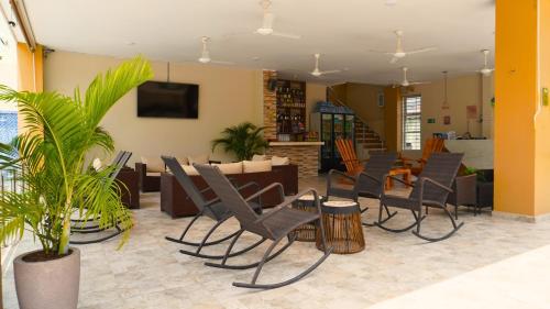 a living room with chairs and a dining room at Hotel y Cabañas Covemar in Coveñas