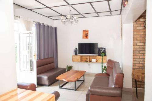 a living room with a couch and a table at Mountain Huye Peak View Haus in Butare