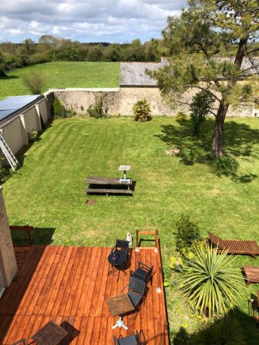 a deck with chairs and a bench on a lawn at Chez MASK Brocante in Yvetot Bocage
