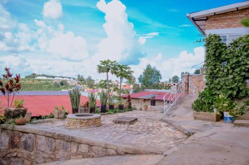 a patio with plants and a brick wall at Mountain Huye Peak View Haus in Butare