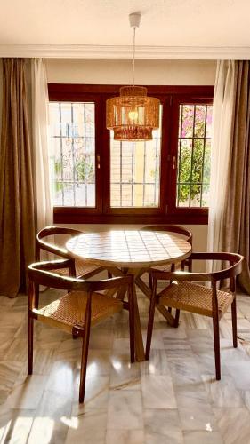 a dining room with a table and chairs and windows at Casa Veranera Vera Costa in Playas de Vera