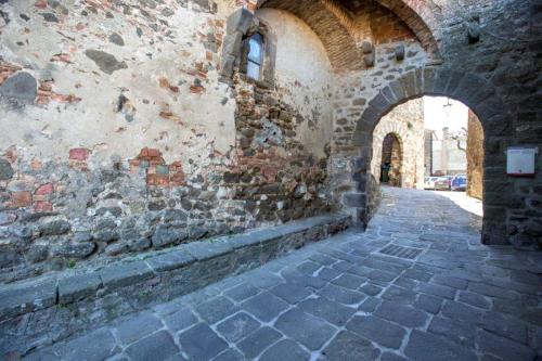 an alley in a stone building with an archway at Casa Vacanze Uno Sguardo Sul Borgo in Montecatini Val di Cecina