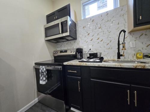 a kitchen with black cabinets and a microwave at G O G Building in Darby