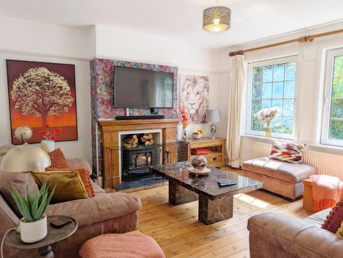 a living room with a fireplace and a tv at Blacksmiths Cottage, Bosham in Bosham