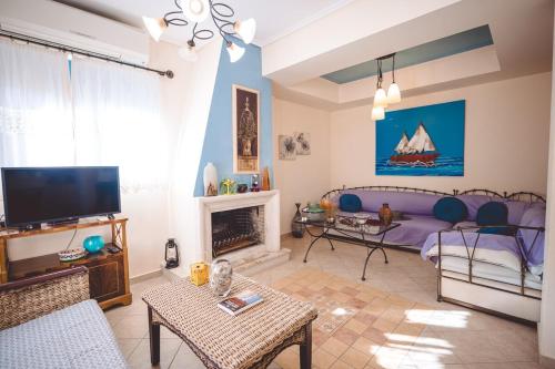 a living room with a purple couch and a fireplace at Villa Sapphire BeachFront Eretria in Eretria