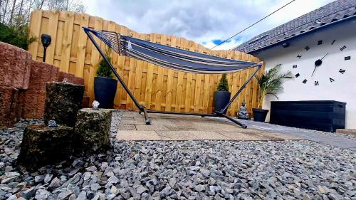 a hammock in front of a wooden fence at Ferienhaus Mefady Jünkerath in Jünkerath
