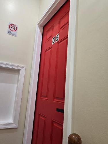 a red door with the number on it in a hallway at G O G Building in Darby