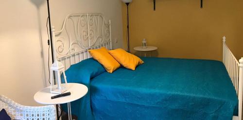 a bedroom with a blue bed with two yellow pillows at Il Canto delle Sirene in Vieste