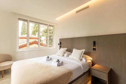 une chambre avec un grand lit blanc avec une fenêtre dans l'établissement Elégant et moderne T4 à 100M de La Croisette, à Cannes