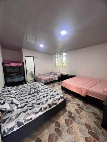 a room with two beds in a room at Finca Hotel Villa el Ocaso Huila in Rivera