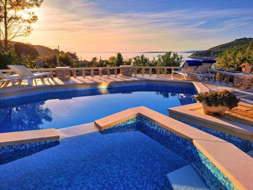 a swimming pool with a view of the water at Villa Stone House Poplat in Vela Luka