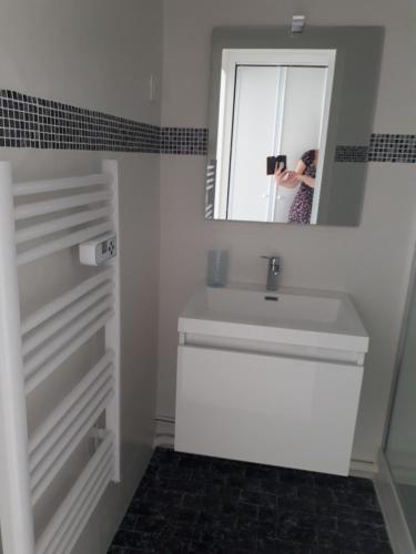 une femme prenant une photo d'un lavabo dans la salle de bains dans l'établissement Studio contemporain vue côté mer, à La Baule