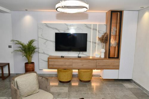 a living room with a flat screen tv on a wall at Luxurious Stella 2-bedroom Apartment with Pool in Hammamet Nord