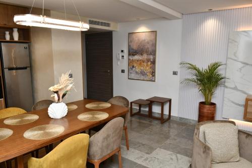 a dining room with a wooden table and chairs at Luxurious Stella 2-bedroom Apartment with Pool in Hammamet Nord