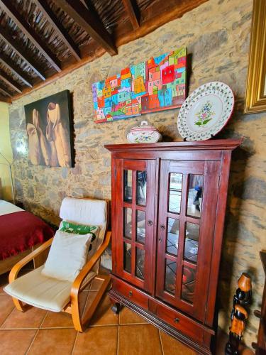 a wooden cabinet and a chair in a room at Casa Maritina in Mogán