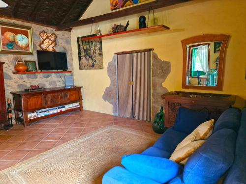 a living room with a blue couch and a tv at Casa Maritina in Mogán