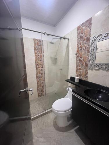 a bathroom with a toilet and a glass shower at Finca Hotel Villa el Ocaso Huila in Rivera