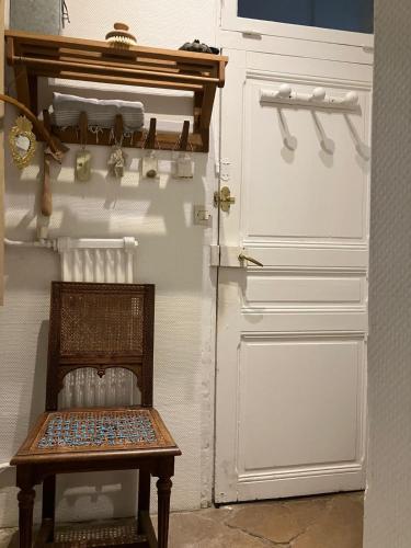 un banc en bois à côté d'une porte blanche dans l'établissement Suite Panthéon-Hôtel Particulier Historique du 17e, à Paris