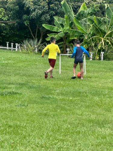 two young boys playing with a soccer ball in a field at Finca Hotel Villa el Ocaso Huila in Rivera