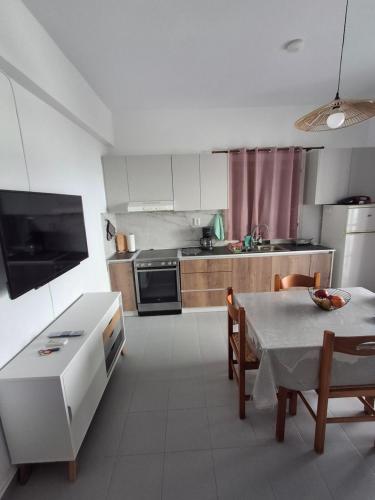 a kitchen with a table and a dining room at Με θέα τον όρμο της Βάρης in Vari
