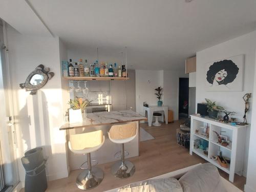 - une cuisine avec une table et deux chaises dans une pièce dans l'établissement Paris La Défense, balcon et vue d'exception 24e etage, à Puteaux